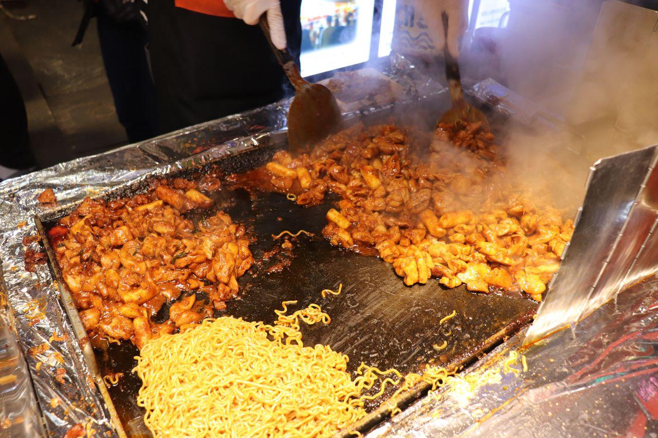 市場中的小吃攤位氛圍，讓顧客在美食和紀念品間流連忘返